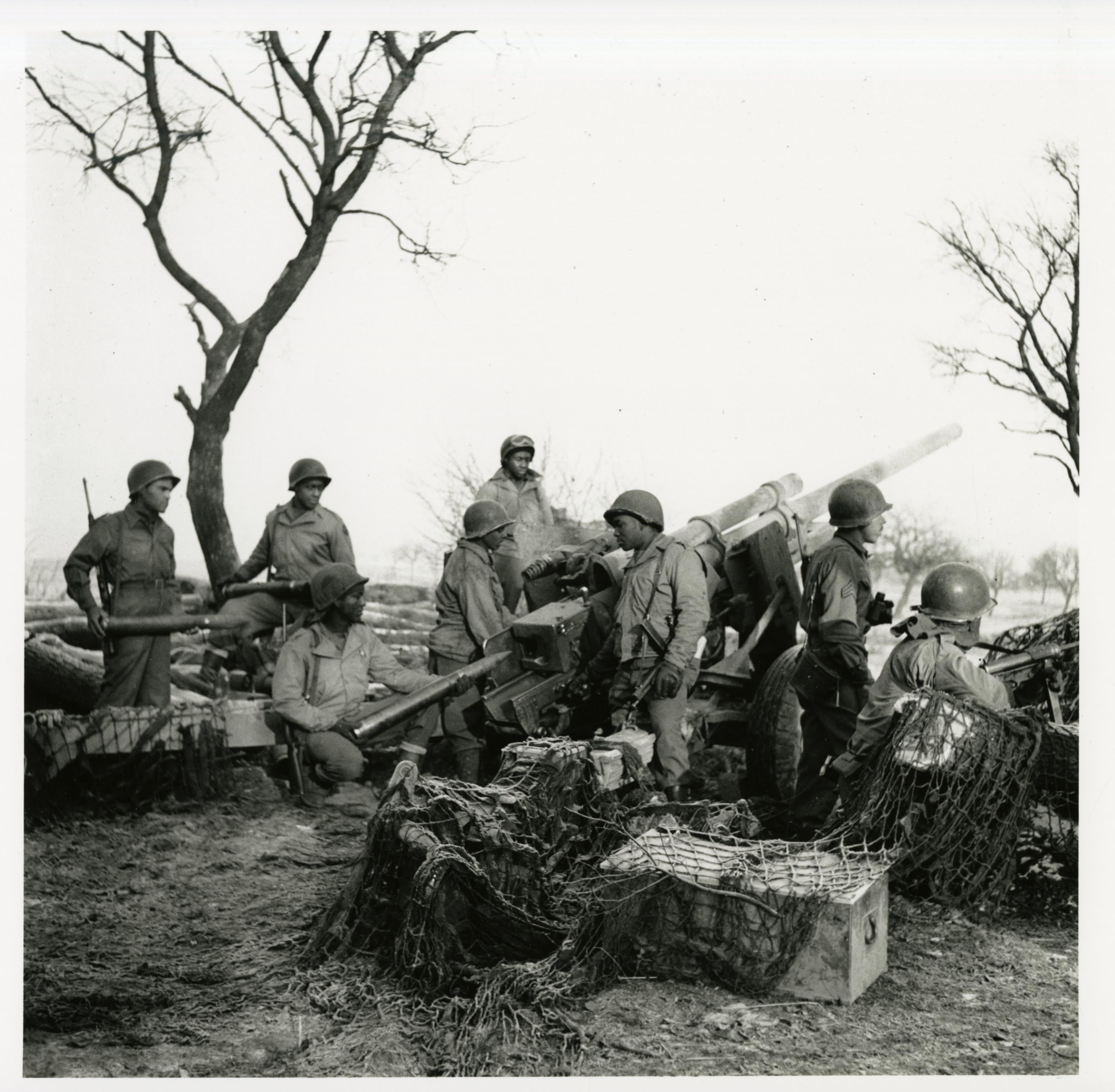 An image of soldiers of the 614th Tank Destroyer Battalion standing around a three inch gun. The image is taken in the year 1945.