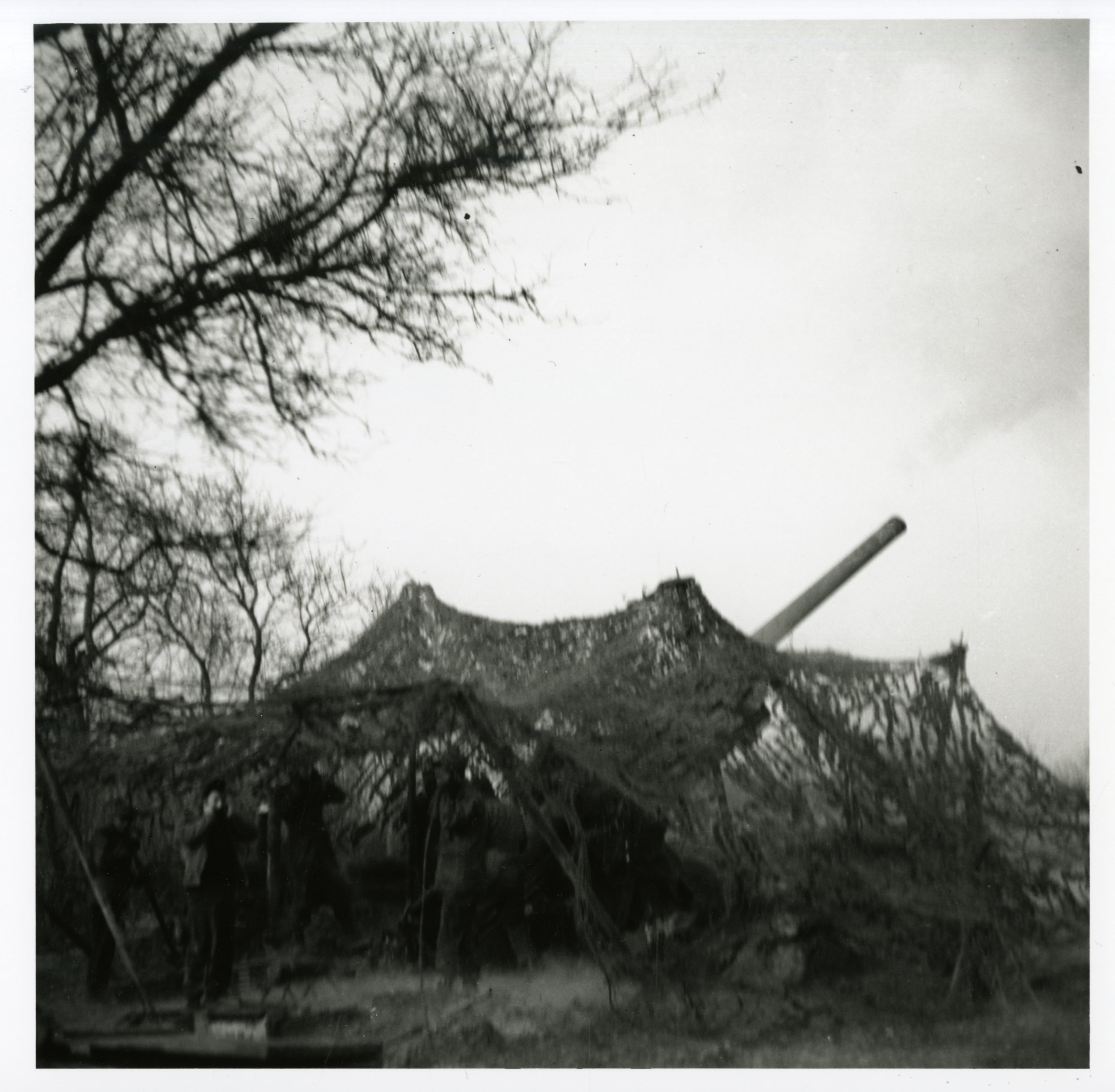 Historical image showing A camouflaged three inch gun of the 614th Tank Destoyer Battalion of Black American soldiers during WWII