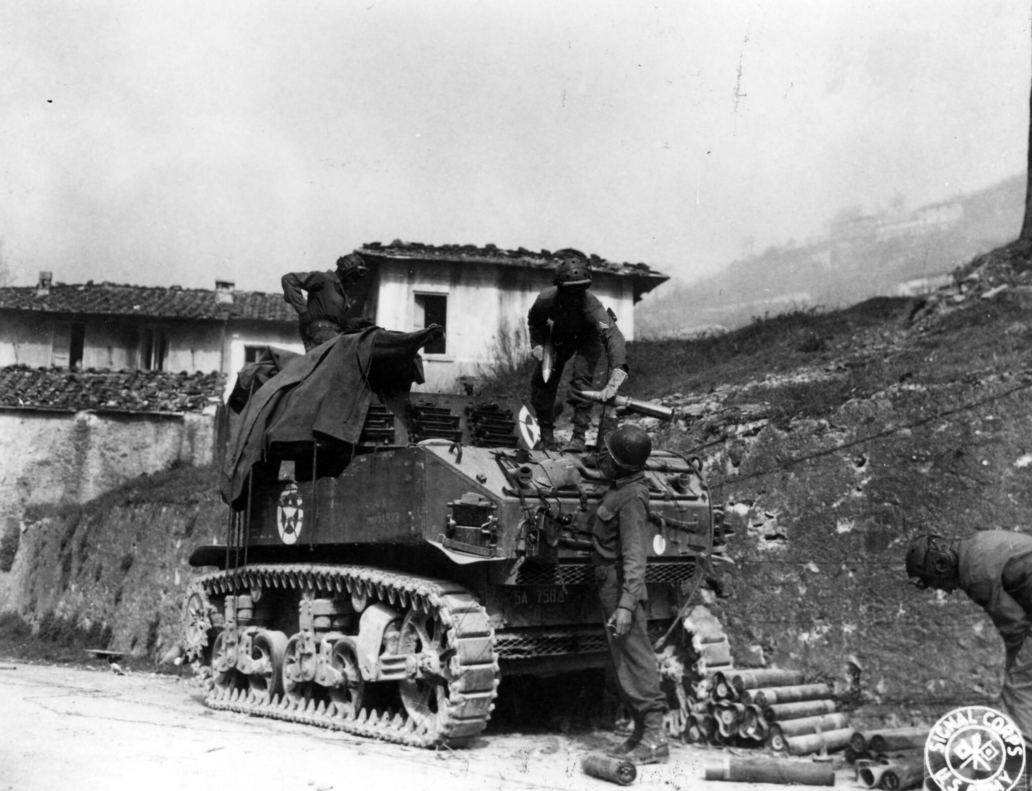 Historical image showing Members of the 758th Light Tank Battalion fire their 75mm howitzer of Black American soldiers during WWII