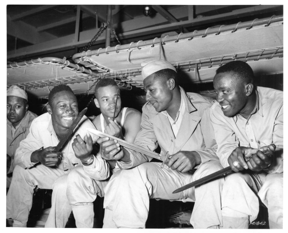 Historical image showing Soldiers of the 76th Coast Artillery Regiment are looking at their bayonets of Black American soldiers during WWII