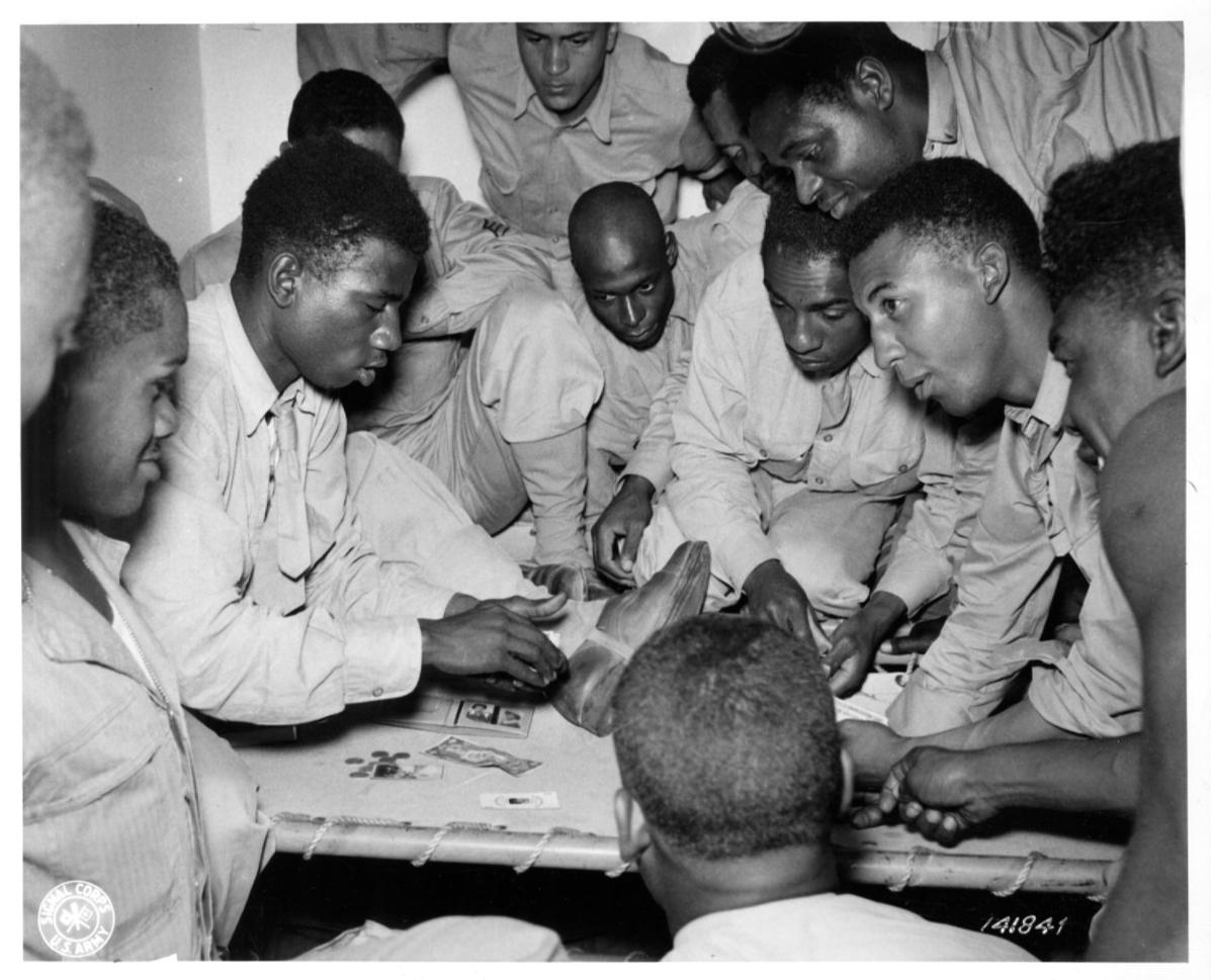 Historical image showing Soldiers of the 76th Coast Artillery are playing blackjack of Black American soldiers during WWII