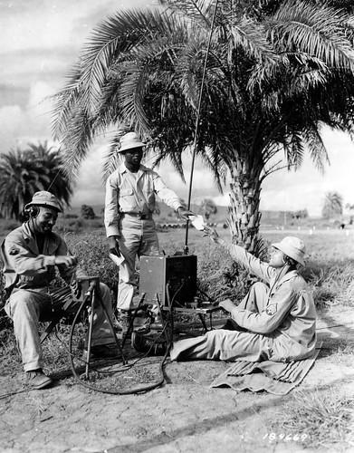 Historical image showing A message is speeded on its way by these men from a Headquarter Detachment of the 903rd Air Base Security Battalion. of Black American soldiers during WWII