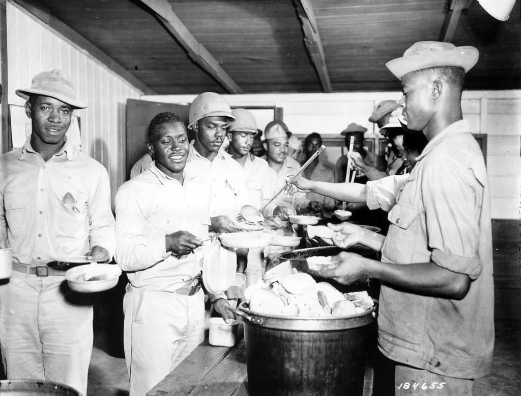 Historical image showing It's chow time for the 903rd 903rd Air Base Security Battalion. of Black American soldiers during WWII