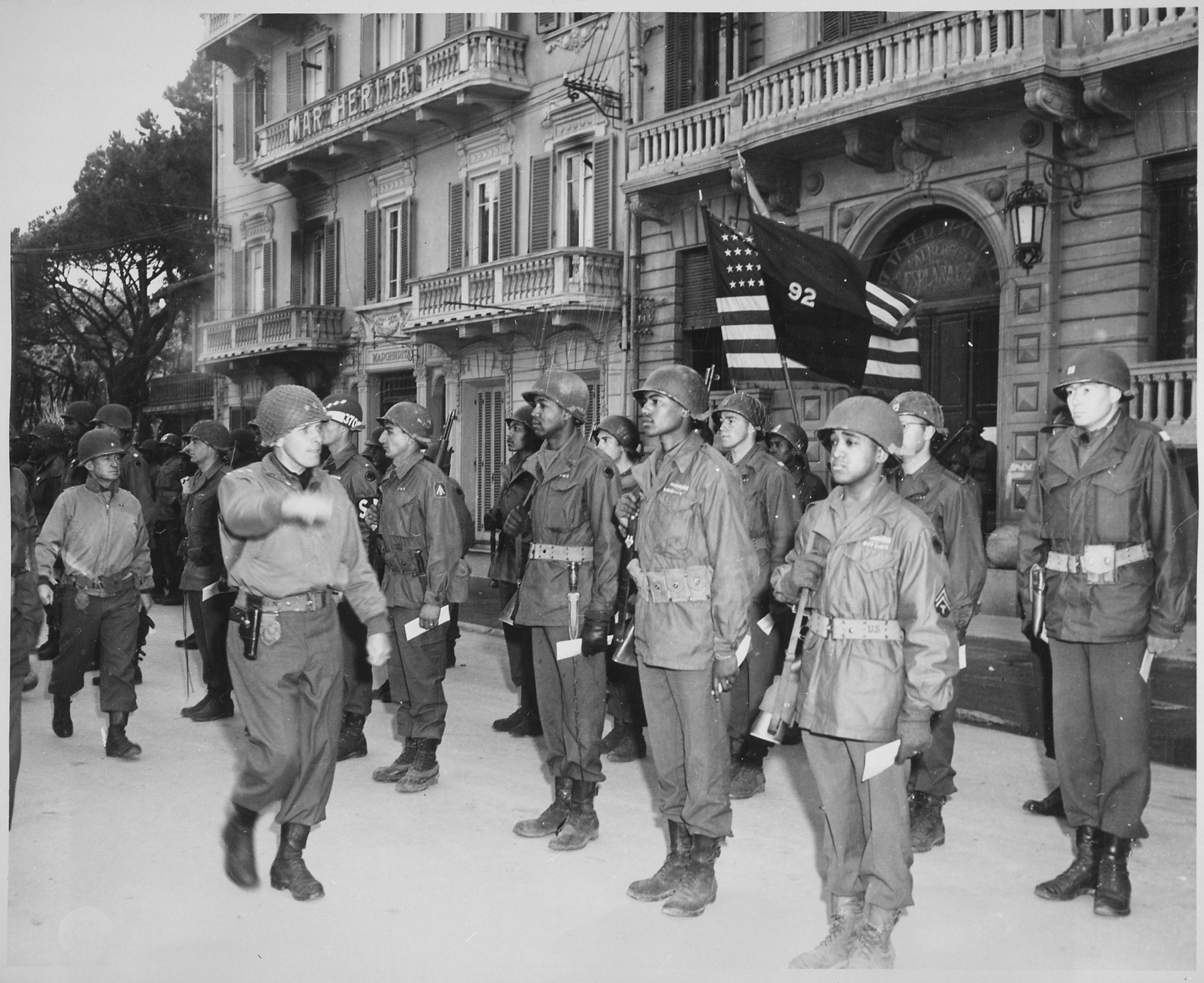 Historical image showing Major General Edward M. Almond, Commanding General of the 92nd Infantry Division, inspects his troops. of Black American soldiers during WWII