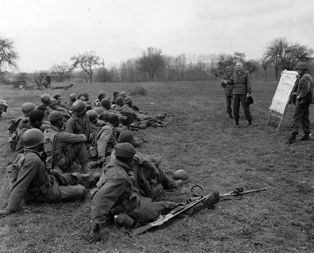 Historical image showing Lieutenant Colonel Nolan Troxell teaches infantry warfare to a group of Black infantry volunteers. of Black American soldiers during WWII