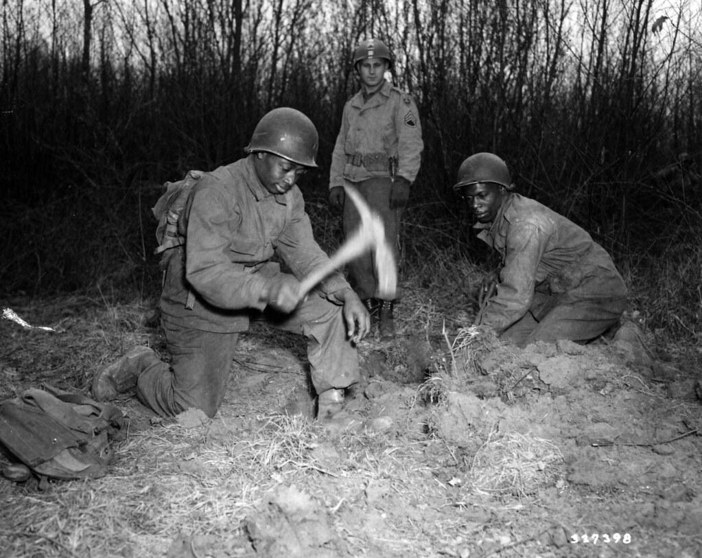 Historical image showing Pvt. Felix Lawson and Pvt. Sammie Jenkins diga foxhole. of Black American soldiers during WWII