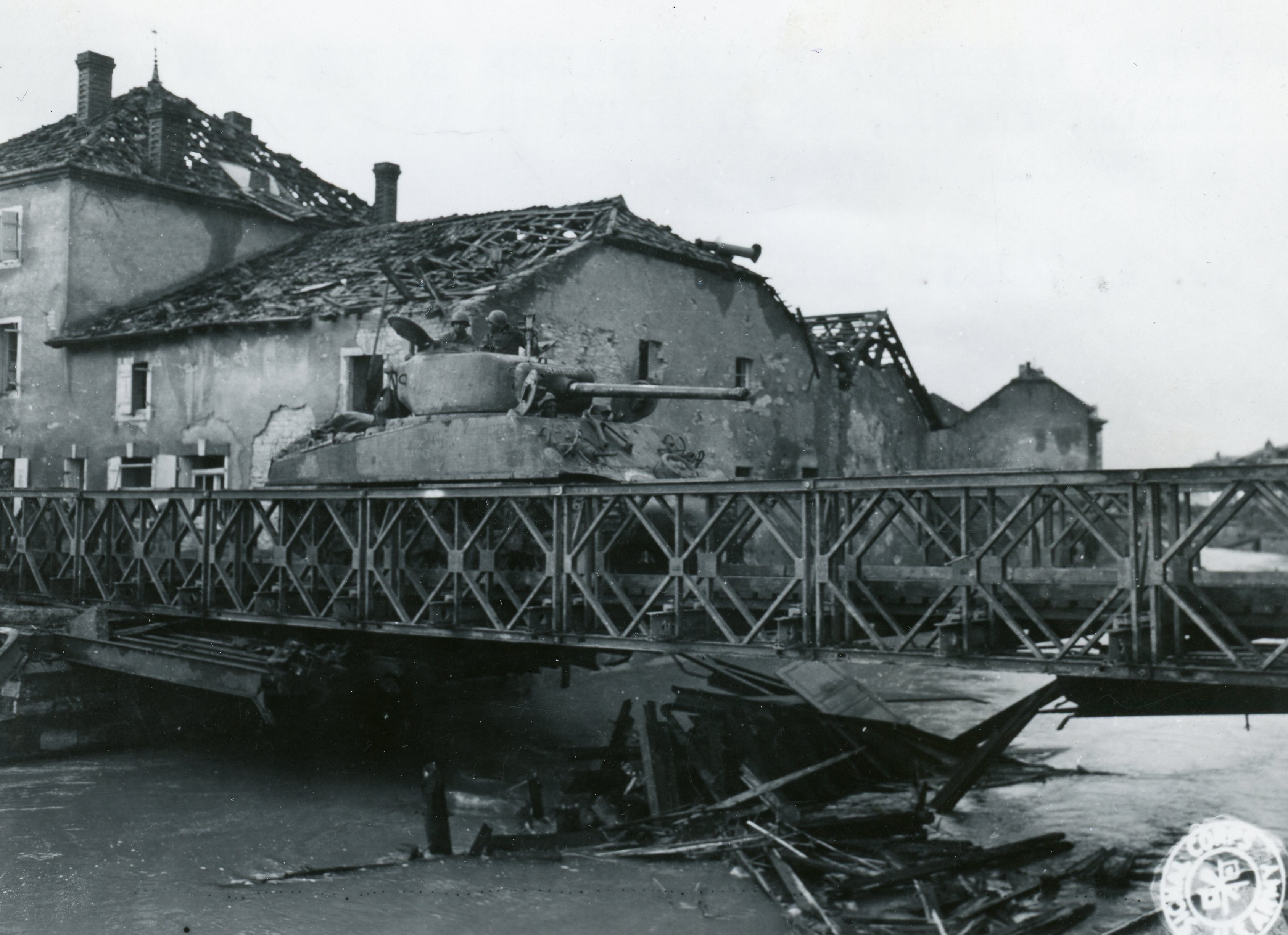 An image of A M4 Sherman tank of the 761st Tank Battalion is crossing a Bailey Bridge in France