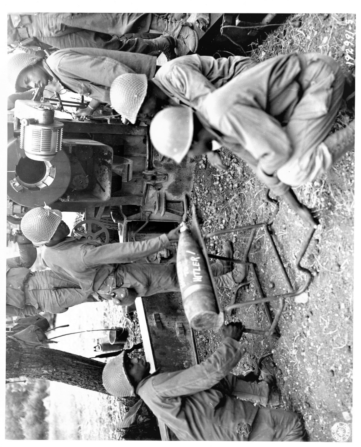 An image of Soldiers of the 999th Field Artillery Battalion are about to fire another shell at a target.