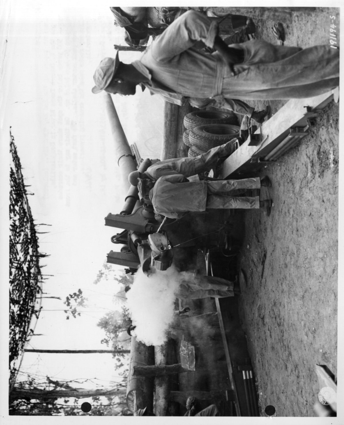 Historical image showing Loading a 155mm M1 rifle of Btry B, 49th Coast Artillery, Section 2, Black troops operating. of Black American soldiers during WWII