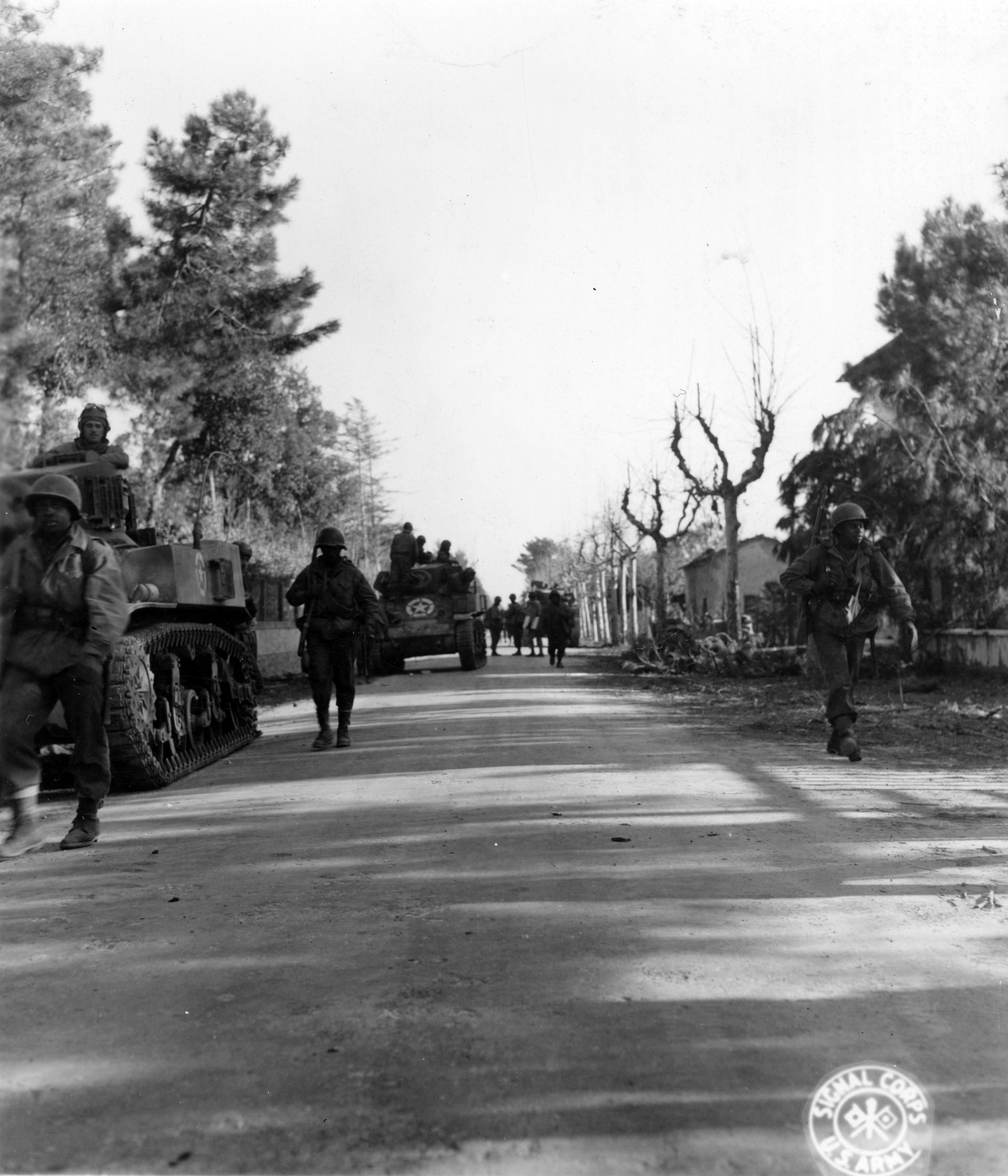 Historical image showing 92nd. Division offensive. Men of 370th Inf. Regt. dismounted from the tanks used to carry them to vicinity of Cinquale Canal, move away from tanks. of Black American soldiers during WWII